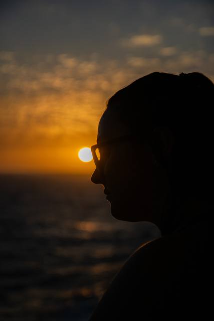 A lone figure against a glowing sunset sky.